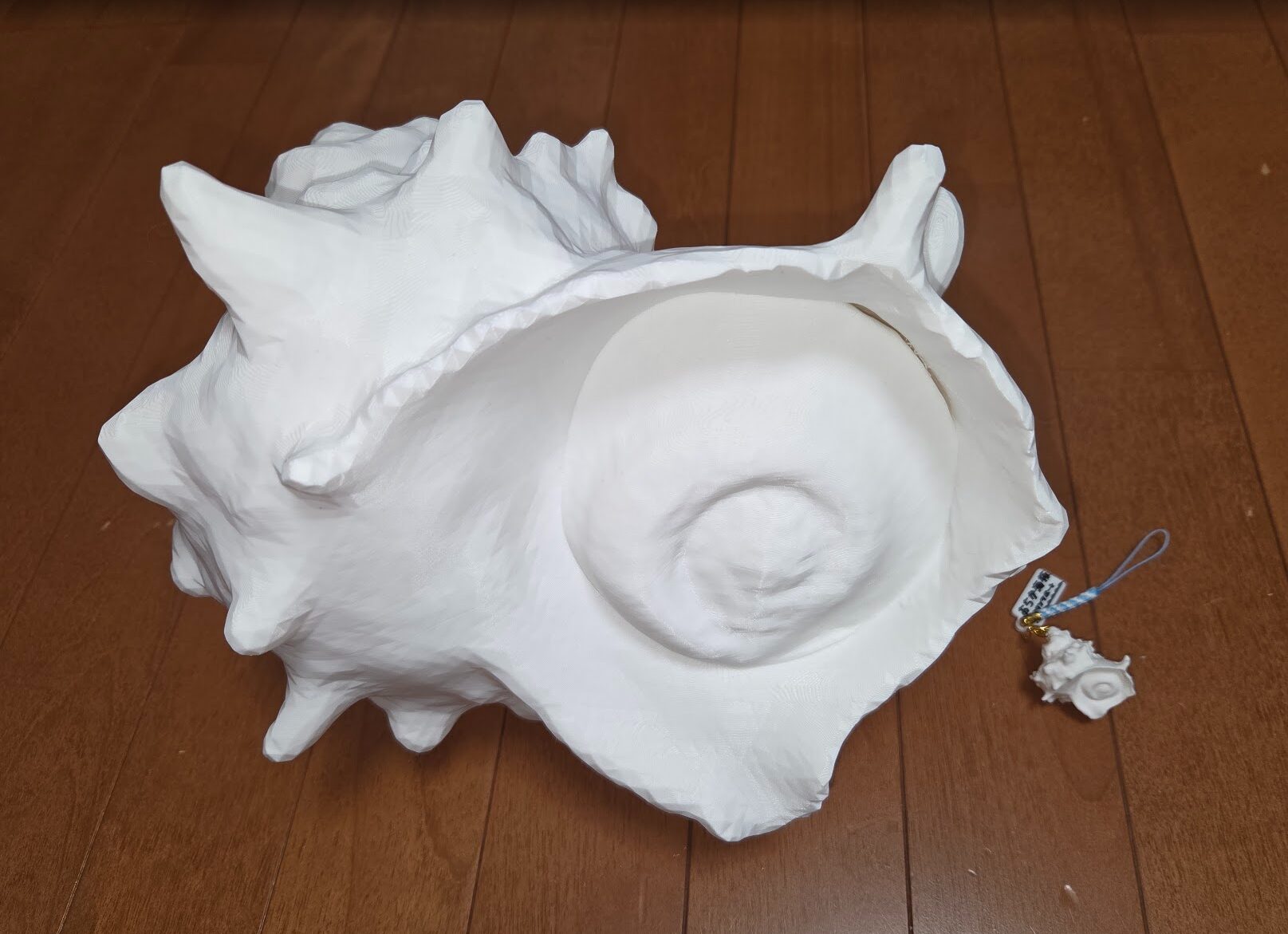 3Dプリンターで造形した大きなサザエと小型のサザエ模型